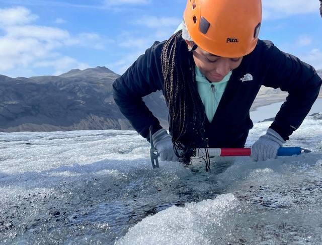 Zaiya in Iceland, on a glacier, with a pickax